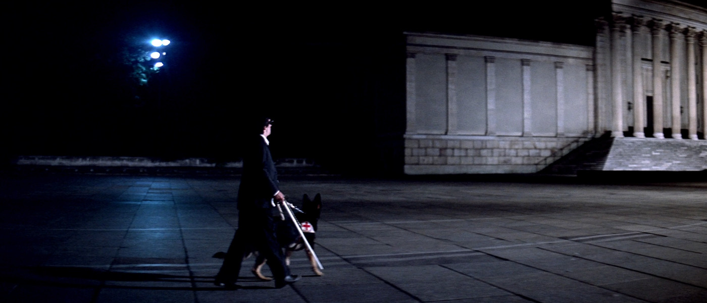 Plaza scene with white cane and red cross from Suspiria
